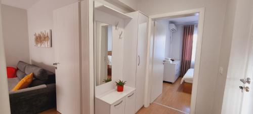 ein weißes Zimmer mit einem Sofa und einem Spiegel in der Unterkunft Comfy apartment- Sunny balcony in Tirana