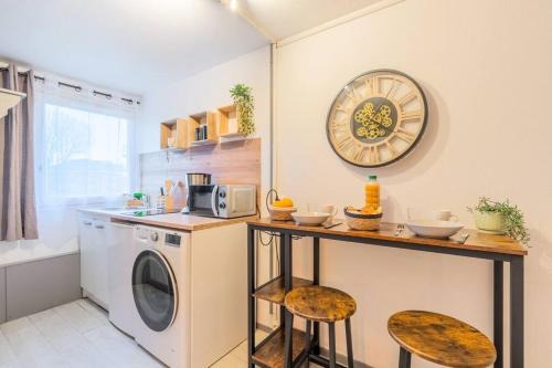 eine Küche mit einer Waschmaschine und einer Theke mit Hockern in der Unterkunft Le Cosy du grand Stadium Lille in Villeneuve d'Ascq