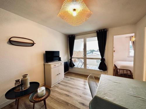 een woonkamer met een eettafel en een slaapkamer bij Appartement cosy à Pontaillac in Vaux-sur-Mer