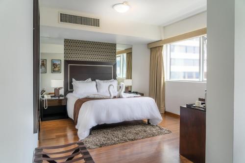 a bedroom with a large bed and a large window at Hotel Jose Antonio in Lima