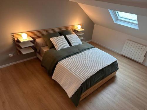 une chambre avec un grand lit avec deux oreillers dans l'établissement Charmant Appartement, à Bohain-en-Vermandois