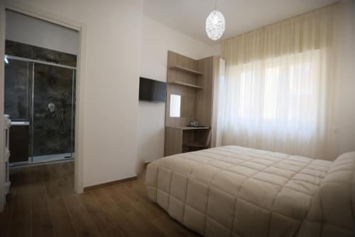 une chambre avec un grand lit et une fenêtre dans l'établissement B&B a Salerno, à Salerne