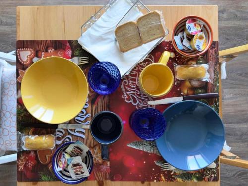 un tavolo con piatti e tazze e pane sopra di Mare Azzurro a Torre del Greco