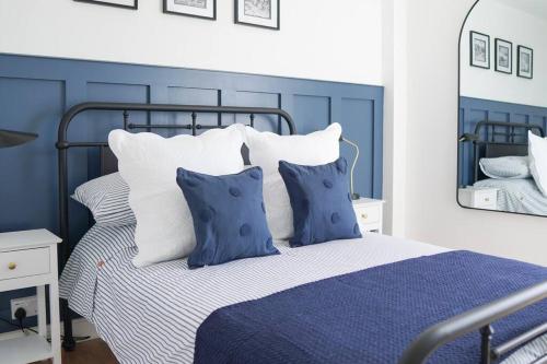 a blue and white bedroom with a bed with pillows at Rye Harbour Cosy Cottage in Rye