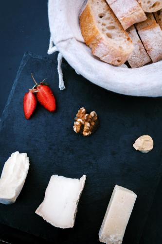 a plate of cheese and strawberries and a bowl of bread at Manoir de Jouralem in Blaison