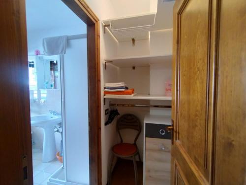 Cette chambre comprend une petite cuisine avec une chaise rouge. dans l'établissement Breakfast around the mountains, à Nebbiu