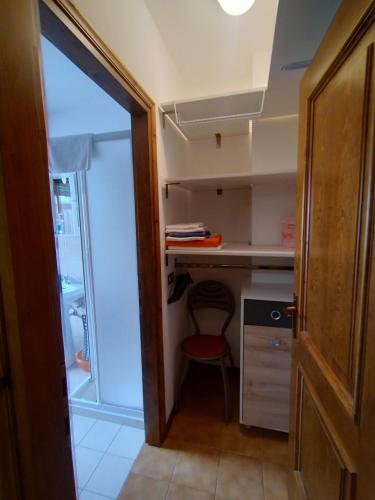 a small kitchen with a refrigerator and a red chair at Breakfast around the mountains in Nebbiu
