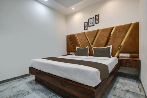 a bedroom with a large bed with a wooden headboard at Hotel DR Green in Dewās