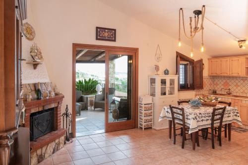 a kitchen and dining room with a table and chairs at Villa Carilù in Altavilla Milicia
