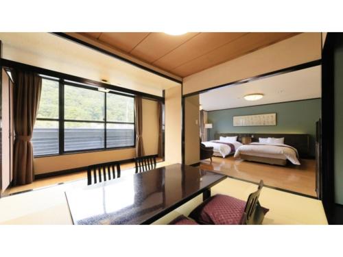 Pokój z łóżkiem i stołem oraz sypialnią w obiekcie Ryokan Biyu no Yado - Vacation STAY 16236v w mieście Yokokura