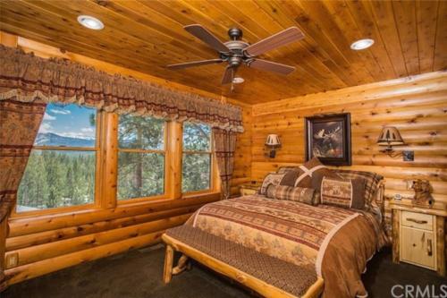 1 dormitorio con 1 cama y ventilador de techo en Peaceful Cabin Home with Breathtaking View!, en Big Bear City