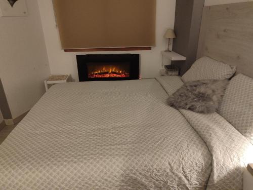 a bedroom with a bed with a fireplace in the background at Descanso en el pirineo in Villanúa