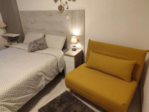 a bedroom with a bed and a yellow couch at Descanso en el pirineo in Villanúa