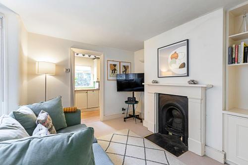 a living room with a couch and a fireplace at Cosy Flat in Battersea Park in London