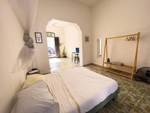 ein Schlafzimmer mit einem weißen Bett in einem Zimmer in der Unterkunft Casa yucateca ZAMA en Santiago. in Mérida