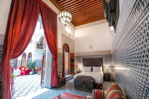 a bedroom with a bed and a large window at Riad La Perle De La Médina in Fez