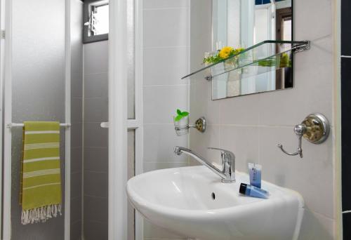 W łazience znajduje się umywalka, lustro i prysznic. w obiekcie Sun City Hotel w Tel Awiwie