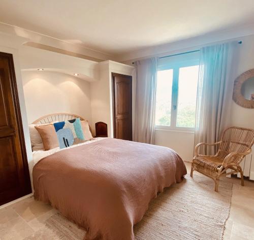 une chambre avec un lit, une chaise et une fenêtre dans l'établissement Villa Les Mésanges, à Sainte-Maxime
