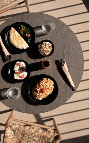 プラキアスにあるKYMANI Boutique Hotel & Suitesの食べ物の皿が置かれたテーブル