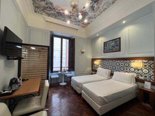 um quarto com 2 camas, uma mesa e uma secretária em Navona Central Suites em Roma
