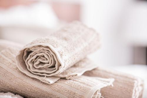 a bundle of towels sitting on top of a bed at Forest Park Garden Apartment in Bratislava