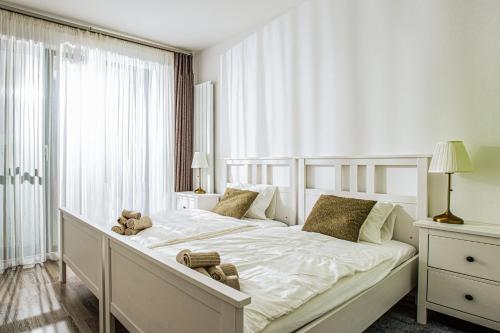 a bedroom with a white bed with a teddy bear on it at Forest Park Garden Apartment in Bratislava