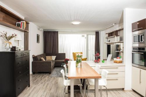 a kitchen and living room with a table and chairs at Forest Park Garden Apartment in Bratislava