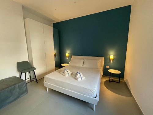 ein Schlafzimmer mit einem weißen Bett und einer grünen Wand in der Unterkunft Casa e Bottega in Manfredonia