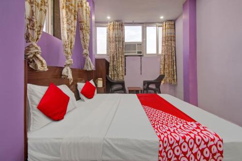 a bedroom with a large bed with red pillows at Hotel Rameshwaram in Jaipur