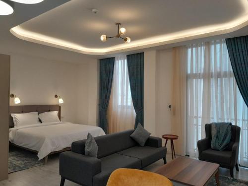 ein Schlafzimmer mit einem Bett, einem Sofa und einem Tisch in der Unterkunft Zemilo Hotel Apartment in Addis Abeba