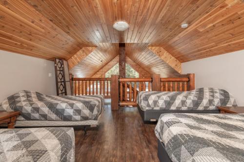 een woonkamer met 2 bedden en een houten plafond bij Cranberry in Valemount