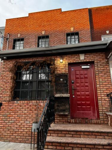 a red door on a brick building with stairs at The Waltham Private Room & Bathroom JFK LGA 10min I 20min ManhattanPenn Station bullet-train in Queens