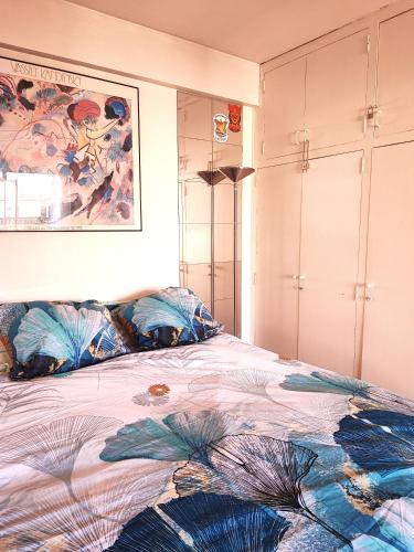 une chambre avec un lit et un tableau au mur dans l'établissement Studio COSY et SPACIEUX AVEC EMPLACEMENT IDEAL, à Paris
