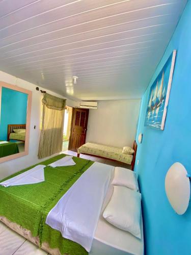 een slaapkamer met een groot bed en een blauwe muur bij Pousada Elpirata Sidney in Ceará-Mirim