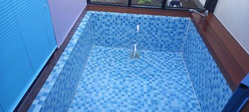 uma vista superior para uma piscina de azulejos azuis em Hamdeok pool villa pension em Jeju