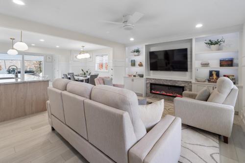 a living room with a couch and chairs and a tv at The Rest at Potomac Farms in Ashburn