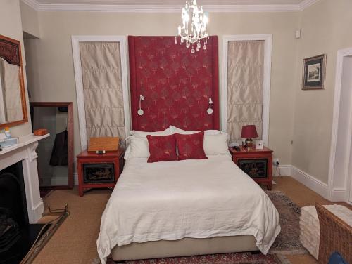 a bedroom with a large bed with a red headboard at La Montagne Observatory in Cape Town