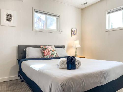 1 dormitorio con 1 cama grande en una habitación con ventanas en Mountain View Duplex / Walk to main street, en Woodland Park