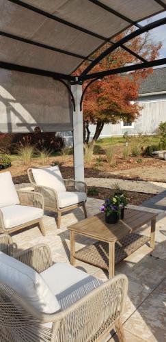 a patio with chairs and a table and an umbrella at The Rest at Potomac Farms in Ashburn