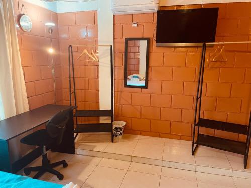 Leño Verde في إسبينال: غرفة بها مكتب وتلفزيون على الحائط