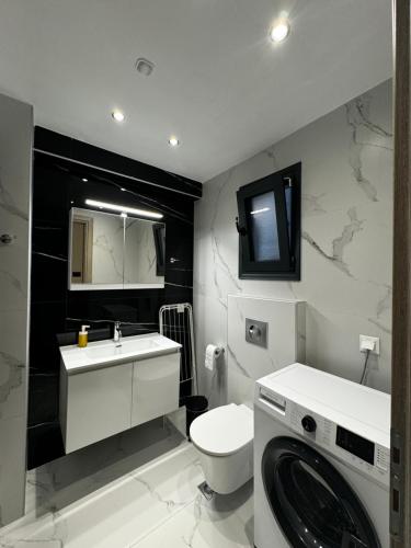 a bathroom with a toilet and a washing machine at ICON Urban Living Trikala in Tríkala