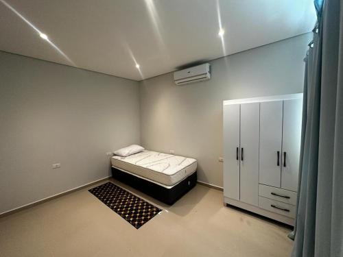 a small room with a bed and a cabinet at Puerta del Lago in San Bernardino