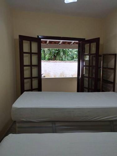 a bedroom with two bunk beds and a window at Apê Aconchegante - 4 pessoas in Bertioga