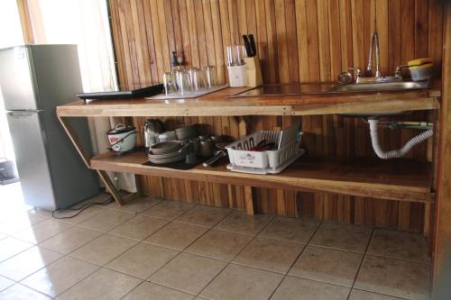 a kitchen with a sink and a shelf with dishes at El Bosque Lodging in Monteverde Costa Rica