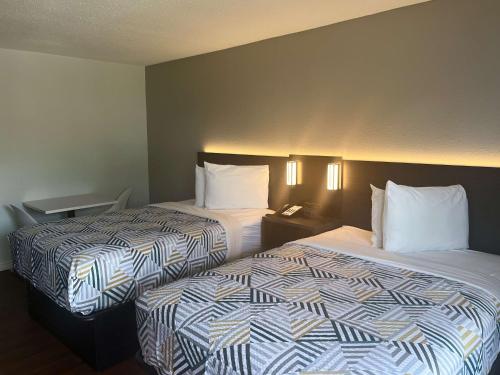 dos camas sentadas una al lado de la otra en una habitación de hotel en Studio 6 Port Lavaca, TX, en Port Lavaca