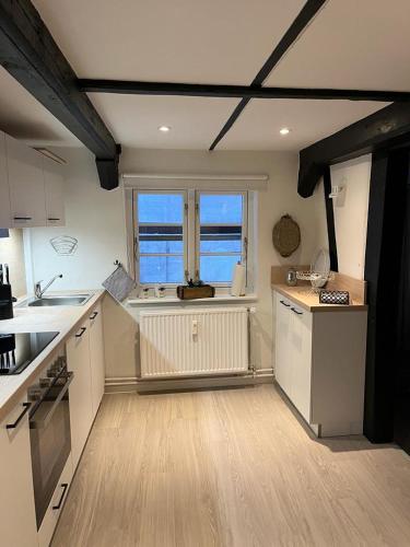 a large kitchen with white cabinets and a window at Zeppelin Koje in Flensburg
