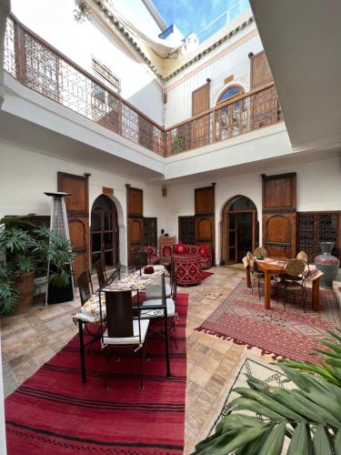ein großes Wohnzimmer mit einem Tisch und Stühlen in der Unterkunft Riad Villa El Arsa in Marrakesch