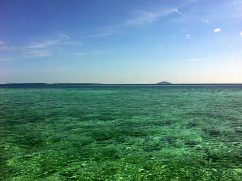 a large body of green water with a blue sky at Bobocha Siladen Boutique Resort in Bunaken