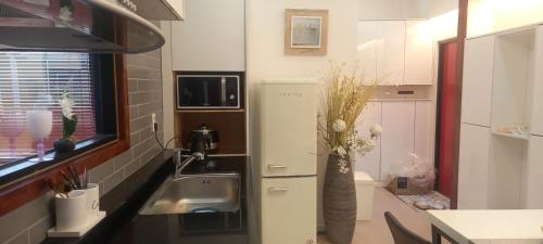 a small kitchen with a sink and a refrigerator at Hamdeok pool villa pension in Jeju