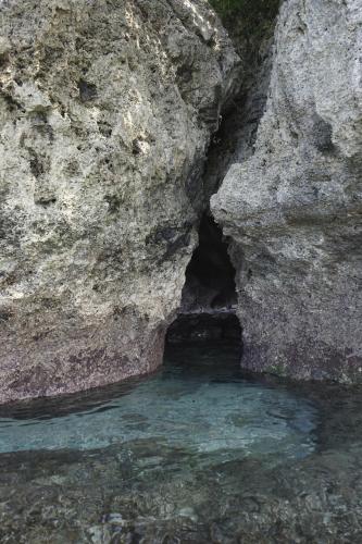 a cave in the rocks next to a body of water at Bobocha Siladen Boutique Resort in Bunaken